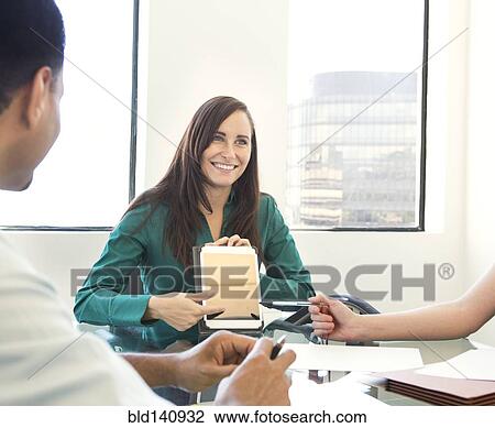 Stock Image - Businesswoman showing work in meeting. Fotosearch