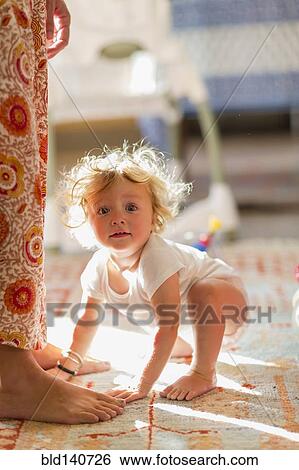 Caucasian baby boy crouching by feet of mother View Large Photo Image Stock Photograph - Caucasian baby boy crouching by feet of mother. Fotosearch