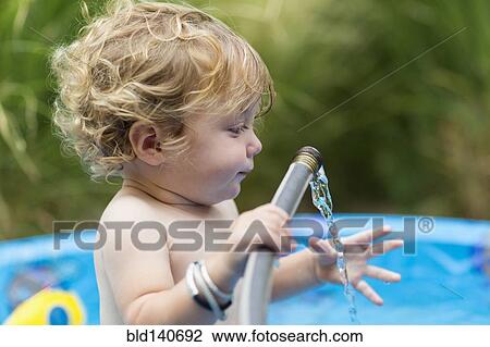Caucasian baby boy playing with hose in swimming pool View Large Photo Image Stock Image - Caucasian baby boy playing with hose in swimming pool. Fotosearch