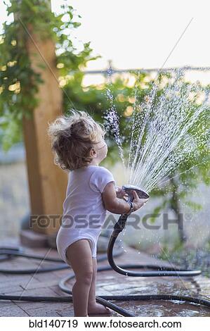 Caucasian baby boy playing with hose on patio View Large Photo Image Stock Photo - Caucasian baby boy playing with hose on patio. Fotosearch