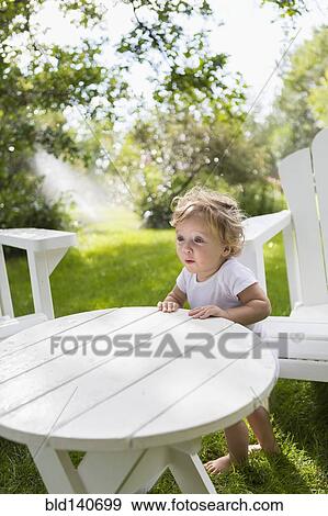 Caucasian baby boy sitting at table in backyard View Large Photo Image Stock Photo - Caucasian baby boy sitting at table in backyard. Fotosearch