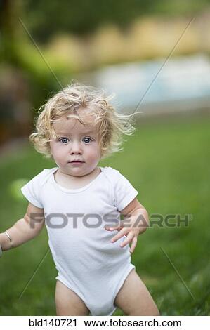 Caucasian baby boy walking in grass View Large Photo Image Stock Image - Caucasian baby boy walking in grass. Fotosearch