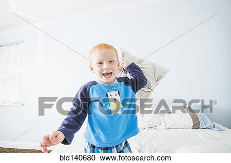 Caucasian boy having pillow fight in bedroom View Large Photo Image Stock Image - Caucasian boy having pillow fight in bedroom. Fotosearch