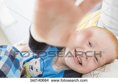 Picture - Caucasian boy playing on bed. Fotosearch