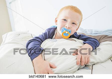 Caucasian boy sucking pacifier in bed View Large Photo Image Stock Image - Caucasian boy sucking pacifier in bed. Fotosearch