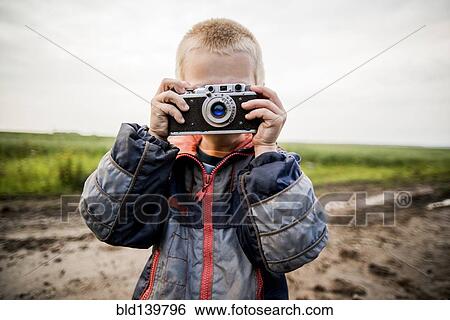 Caucasian boy taking photograph in rural field View Large Photo Image Stock Photograph - Caucasian boy taking photograph in rural field. Fotosearch
