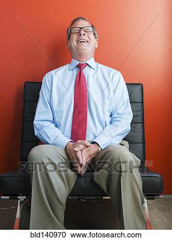 Caucasian businessman laughing in chair View Large Photo Image Stock Image - Caucasian businessman laughing in chair. Fotosearch