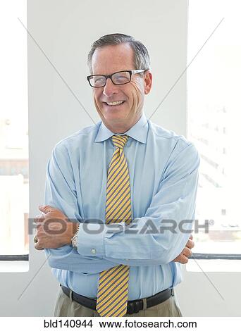 Caucasian businessman smiling in office View Large Photo Image Picture - Caucasian businessman smiling in office. Fotosearch