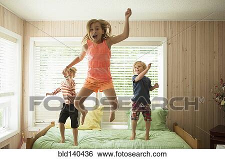 Caucasian children jumping on bed View Large Photo Image Stock Photograph - Caucasian children jumping on bed. Fotosearch