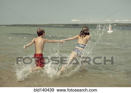 Caucasian children splashing together into lake View Large Photo Image Stock Photo - Caucasian children splashing together into lake. Fotosearch