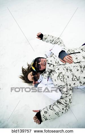 Stock Photo - Caucasian couple playing in snow. Fotosearch