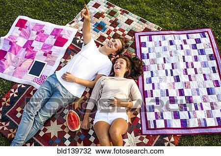 Caucasian couple relaxing on blankets in park View Large Photo Image Stock Image - Caucasian couple relaxing on blankets in park. Fotosearch