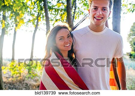 Stock Photo - Caucasian couple wrapped in American flag. Fotosearch