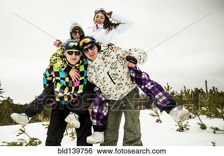Stock Photograph - Caucasian friends playing together in snow. Fotosearch
