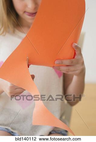Stock Image - Caucasian girl cutting construction paper. Fotosearch