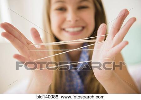 Stock Photography - Caucasian girl playing cats cradle game. Fotosearch