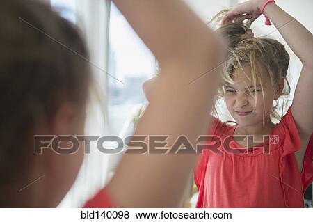 Caucasian girl playing with her hair at mirror View Large Photo Image Stock Photo - Caucasian girl playing with her hair at mirror. Fotosearch