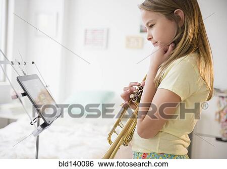 Caucasian girl practicing trumpet with digital tablet View Large Photo Image Stock Photograph - Caucasian girl practicing trumpet with digital tablet. Fotosearch