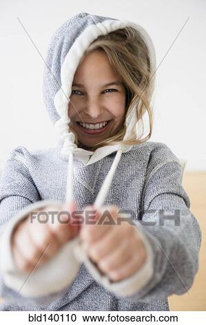 Caucasian girl pulling strings of hood View Large Photo Image Stock Image - Caucasian girl pulling strings of hood. Fotosearch