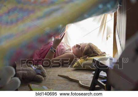 Caucasian girl reading in blanket fort View Large Photo Image Stock Photography - Caucasian girl reading in blanket fort. Fotosearch