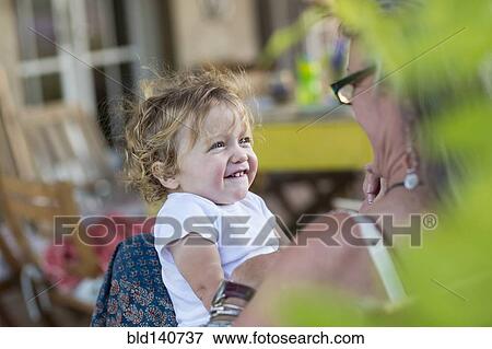 Stock Photo - Caucasian grandmother and baby grandson smiling outdoors. Fotosearch