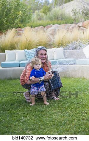 Caucasian grandmother hugging baby grandson in backyard View Large Photo Image Stock Image - Caucasian grandmother hugging baby grandson in backyard. Fotosearch