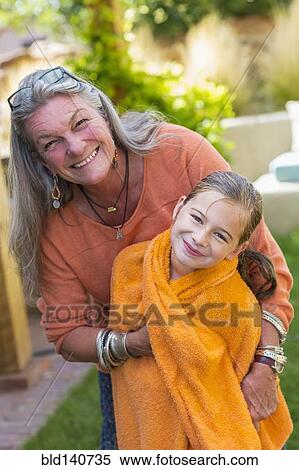 Caucasian grandmother wrapping granddaughter in towel in backyard View Large Photo Image Stock Photography - Caucasian grandmother wrapping granddaughter in towel in backyard. Fotosearch