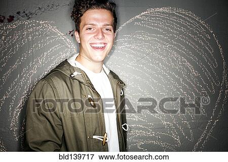 Caucasian man smiling near chalk heart on wall View Large Photo Image Stock Photo - Caucasian man smiling near chalk heart on wall. Fotosearch