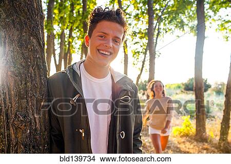Picture - Caucasian man smiling with girlfriend in park. Fotosearch