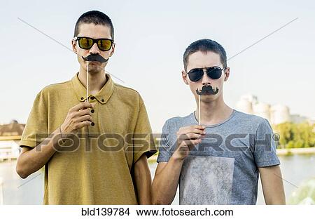 Caucasian men playing with fake mustaches in city View Large Photo Image Picture - Caucasian men playing with fake mustaches in city. Fotosearch