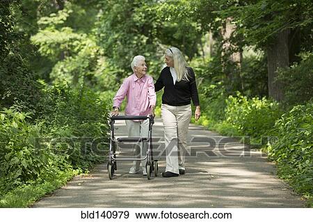 Caucasian mother and daughter walking in park View Large Photo Image Stock Photo - Caucasian mother and daughter walking in park. Fotosearch