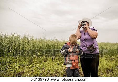 Caucasian mother and son taking photographs in rural field View Large Photo Image Stock Image - Caucasian mother and son taking photographs in rural field. Fotosearch