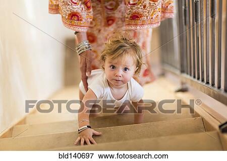 Caucasian mother helping baby son climb stairs View Large Photo Image Stock Photo - Caucasian mother helping baby son climb stairs. Fotosearch