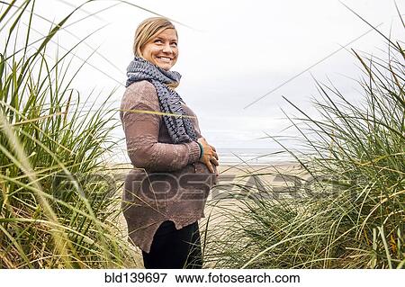 Caucasian pregnant woman holding her stomach on beach View Large Photo Image Stock Photo - Caucasian pregnant woman holding her stomach on beach. Fotosearch