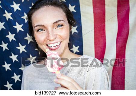 Caucasian woman eating ice cream near American flag View Large Photo Image Stock Photo - Caucasian woman eating ice cream near American flag. Fotosearch