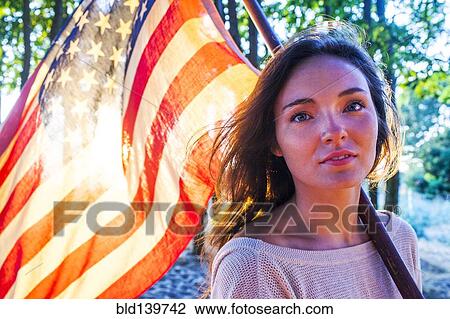 Caucasian woman holding American flag View Large Photo Image Stock Image - Caucasian woman holding American flag. Fotosearch