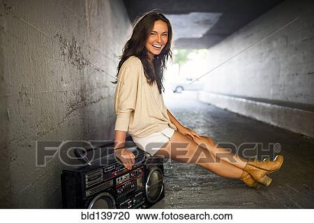 Caucasian woman sitting on boom box in tunnel View Large Photo Image Stock Image - Caucasian woman sitting on boom box in tunnel. Fotosearch