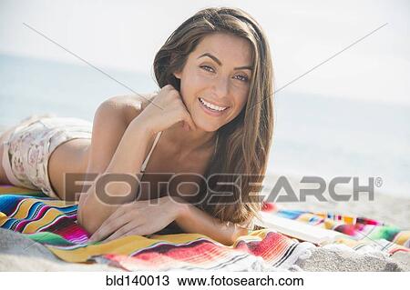 Caucasian woman smiling and laying on blanket at beach View Large Photo Image Stock Image - Caucasian woman smiling and laying on blanket at beach. Fotosearch