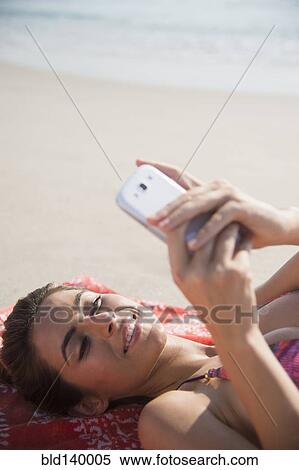 Caucasian woman using cell phone on beach View Large Photo Image Stock Photography - Caucasian woman using cell phone on beach. Fotosearch