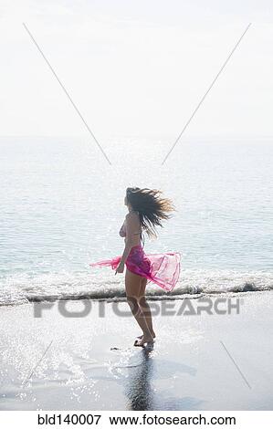 Caucasian woman wading at beach View Large Photo Image Stock Photo - Caucasian woman wading at beach. Fotosearch