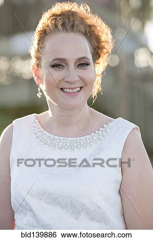 Stock Photograph - Caucasian woman wearing evening gown outdoors. Fotosearch