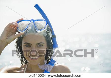 Picture - Caucasian woman wearing snorkel and mask in ocean. Fotosearch