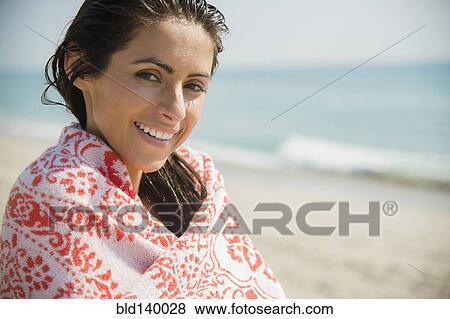 Stock Photo - Caucasian woman wrapped in towel on beach. Fotosearch
