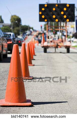 Stock Image - Close up of traffic cones on busy street. Fotosearch
