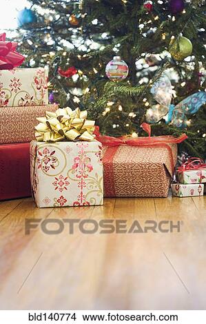 Picture - Close up of wrapped gifts under Christmas tree. Fotosearch