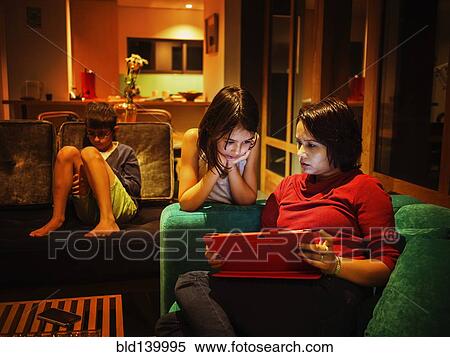 Stock Photography - Family relaxing together in living room. Fotosearch