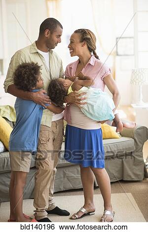 Stock Photograph - Family smiling together in living room. Fotosearch