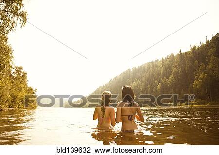 Girls standing together in lake View Large Photo Image Stock Image - Girls standing together in lake. Fotosearch