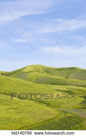 Stock Photograph - Hills and blue sky in rolling landscape. Fotosearch