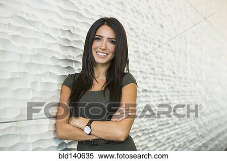 Hispanic businesswoman smiling near wall View Large Photo Image Stock Photography - Hispanic businesswoman smiling near wall. Fotosearch